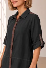 Vestido midi chemise de lino color beige, con cierre frontal de botones, cuello camisero, mangas cortas con vuelta y detalles en marrón oscuro en la botonera y los hombros.