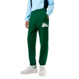Pantalón de jogging verde oscuro con puños elásticos y cintura ajustable con cordón. Presenta bolsillos laterales y logo de Lacoste estampado en blanco en la pierna izquierda.