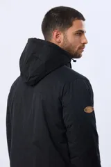Campera puffer reversible para hombre, de color negro, con diseño capitonado, capucha integrada y bolsillos funcionales con cierre frontal.