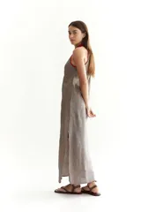 Vestido largo suelto de lino color gris con cuello halter y detalles en rojo.