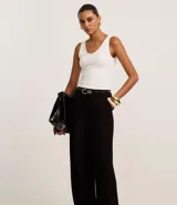 Pantalón de vestir azul marino, de corte amplio, con cintura alta, cinturón incorporado y cierre delantero.