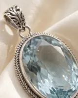 Dije de plata 925 con diseño ovalado y piedra aguamarina facetada en el centro, perteneciente a la línea Hindi.