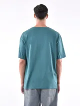 Remera de manga corta color beige, con corte oversize y cuello redondo.