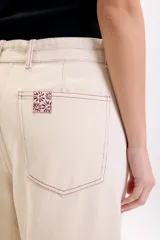 Pantalón casual beige de corte recto, con bolsillos laterales y pespuntes en contraste.