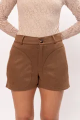 Short de gamuza con lycra, color negro, con cierre frontal, botón y dos bolsillos delanteros.