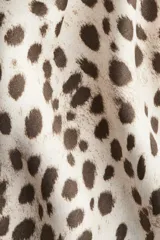 Pollera midi de corte evasé con caída fluida y acabado satinado. Presenta un estampado de leopardo en tonos neutros y cintura elástica para un ajuste cómodo.