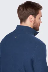 Buzo gris de tejido grueso con cuello alto y medio cierre con botones.