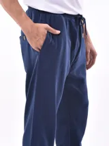 Pantalón deportivo negro, tipo jogging, con cordón ajustable en la cintura y puños elásticos en los tobillos.