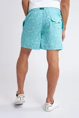 Short de baño con cintura elástica y cordón ajustable, confeccionado en tela ligera de secado rápido. Presenta un estampado botánico integral en tonos amarillos, blancos y azules, con dos bolsillos delanteros y uno posterior.