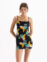Vestido corto de calce al cuerpo, color negro con estampado frutal de bananas y hojas. Presenta escote recto con breteles finos.