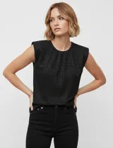 Blusa negra sin mangas de gasa labrada, marca Floral & Ivy. Tiene abertura central en la espalda con botón, aplique interno de hombreras y forro interno a tono.