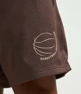 Bermuda deportiva masculina color marrón, confeccionada con tecnología Dry que evapora el sudor. Tiene cintura elástica con cordón ajustable y estampado de baloncesto.
