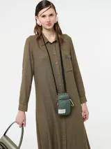 Vestido camisero largo color rojo, confeccionado en lino y viscosa, con cartera de botones delanteros centrales y bolsillo delantero superior con terminación de galón metalizado.