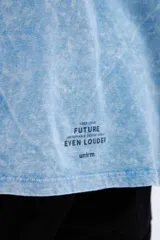 Remera celeste con efecto marmolado, bolsillo en el pecho con parche decorativo y arte en la espalda baja. De calce oversize y algodón lavado con textura extra suave.