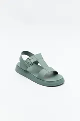 Sandalia baja negra con tiras anchas y hebilla lateral.