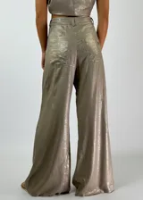 Pantalón blanco de corte palazzo, tiro alto y cintura elástica. Confeccionado en tela ligera con textura.