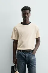 Camiseta de manga corta y cuello redondo, color azul marino, con ribete de contraste en color crema alrededor del cuello.