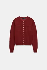 Chaqueta de punto bordó con cuello redondo, manga larga y bolsillos de plastrón en el delantero. Cuenta con cierre frontal de botones.