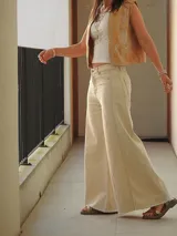 Pantalón de jean color natural, de corte ancho con costuras a la vista y terminación desflecada.