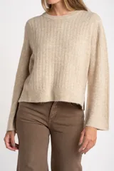 Sweater de punto color beige melange, con cuello redondo y manga larga. Presenta un tejido texturado con relieve vertical.