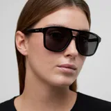 Lentes de sol estilo aviador con montura oversized de color negro y doble puente. Cuentan con lentes oscuras de nylon con protección UV400.