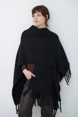 Ruana de tejido de punto en color negro, con diseño de cuello alto y terminaciones con flecos en los bordes.