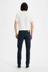 Jean de corte skinny y tiro medio, en color azul oscuro con acabado uniforme. Presenta costuras reforzadas y cierre frontal con botón y cremallera.