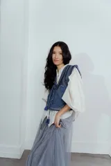 Chaleco de jean azul con bordados y estampado en el interior.