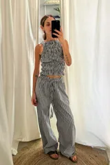 Pantalón de corte recto y holgado, con estampado de cuadros vichy en rojo y blanco. Tiene cintura elástica con cordón ajustable.