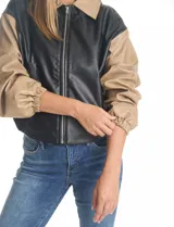 Chaqueta bomber de eco cuero color verde oliva, con cuello tipo solapa, cierre frontal metálico, bolsillos laterales y puños elásticos.