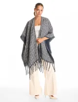 Ruana de tejido tweed en tonos verdes con destellos de lurex, diseño abierto con terminación de flecos en los bordes.