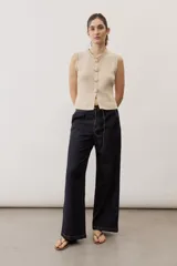 Jean azul oscuro de corte wide leg, con cintura elástica ajustable mediante cordón y bolsillos laterales.