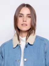 Campera de jean color blanco con corderito en el cuello y en el interior. Cuenta con dos bolsillos en la parte delantera, botones metálicos y elástico en el bajo.