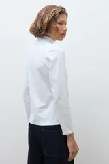 Remera de manga larga con detalle de puntilla en los puños, confeccionada en tejido suave y elástico.
