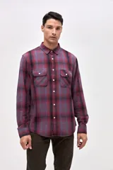 Sobrecamisa de algodón con diseño de cuadros en tonos bordó y azul. Presenta cuello clásico, cierre frontal con botones y dos bolsillos en el pecho con solapa.