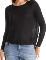 Buzo de tejido de hilado fino, color negro, con mangas largas corte raglán y cuello redondo. Presenta un diseño con largo de espalda mayor al delantero.