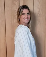 Blusa de manga larga con diseño a rayas verticales, cuello redondo y detalle de volados en los hombros.