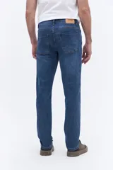 Jean de corte recto y tiro medio con efecto lavado, confeccionado en tejido de algodón con spandex. Cuenta con cierre frontal, botón y pasacintos.