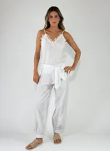 Pantalón beige con textura arrugada, de corte holgado estilo balloon con puños elásticos en los tobillos y cintura alta con faja y lazo ajustable.