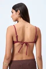 Top de bikini azul con textura fruncida y detalle de aro al frente. Posee breteles finos regulables y un calce cómodo que realza el busto con un toque moderno.