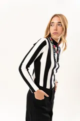 Polera de tejido de punto con diseño de rayas verticales anchas en blanco y negro, cuello alto y manga larga.