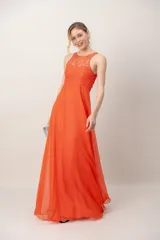 Vestido largo color coral con escote halter, corsé superior bordado con piedras y falda amplia y ligera de gasa.