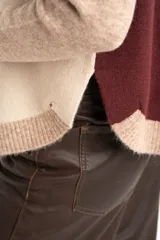 Sweater de punto con diseño color block en tonos beige, marrón y bordó, de cuello redondo y manga larga con puños acanalados en contraste.