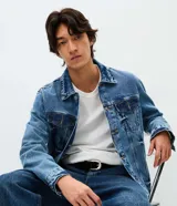 Campera de jean azul para hombre, con efecto desteñido, cuello inglés, cierre frontal de botones metálicos y bolsillos frontales con solapa.