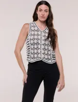 Chaleco de crochet color blanco con detalles en negro, escote en V y cierre frontal con botones.