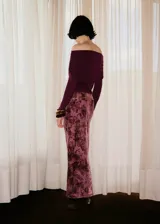 Jersey de punto fino color bordó, con diseño entallado, cuello drapeado estilo palabra de honor y mangas largas.