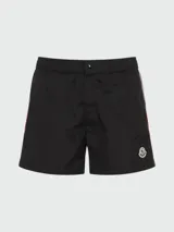 Short de baño negro con cintura elástica y cordón ajustable. Presenta una franja tricolor (rojo, blanco y azul) en los laterales y el logo de Moncler en el bajo.