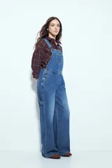 Enterito de denim negro con calce relajado y silueta amplia, inspirado en la estética workwear. Presenta tiradores regulables, pechera con bolsillo frontal y bolsillos laterales funcionales.