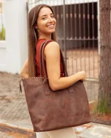 Bolso tipo tote de cuero vacuno color marrón caoba, con diseño artesanal que presenta costuras decorativas en el borde superior y asas fijas de hombro.