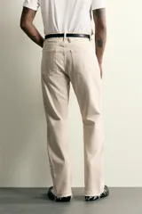 Jeans flare fit de tiro medio confeccionados en denim de algodón color beige, con cinco bolsillos, efecto salpicaduras y bajo irregular.